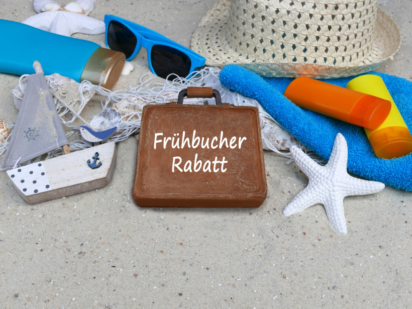 Frühbucher-Rabatt sichern – günstiger Urlaub mit Preisvorteil Strandmotiv mit Sonnencreme, Handtuch, Sommerhut und Koffer mit der Aufschrift Frühbucher Rabatt – Symbolbild für günstiges Vorab-Buchen