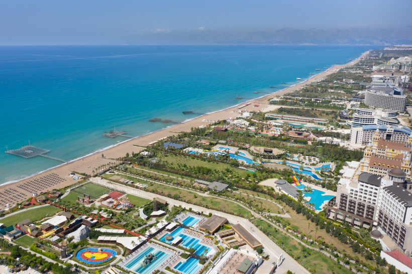 Luftaufnahme der Hotel- und Strandzone von Lara Beach in Antalya mit weitläufiger Küste – beliebtes Ziel für Badeurlaub in Antalya.
