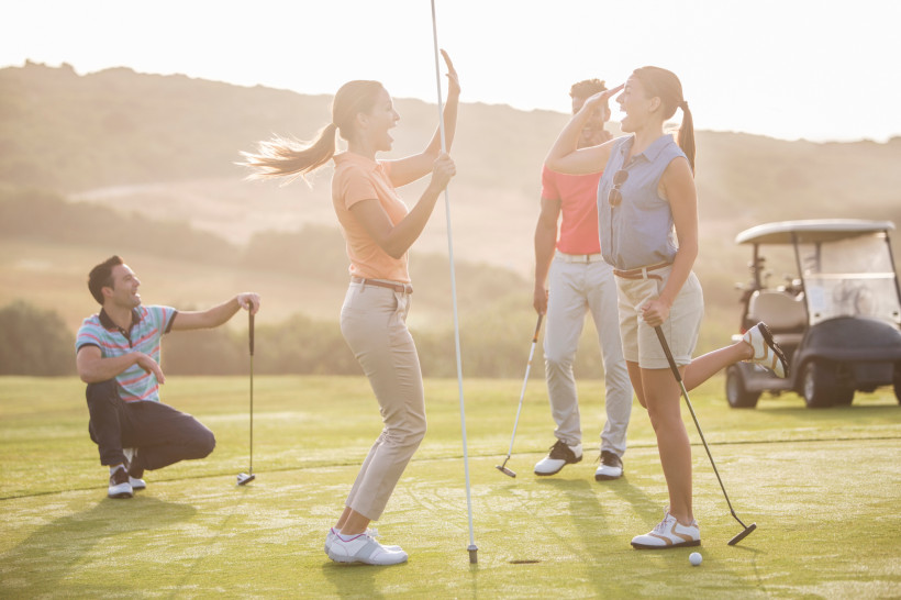Golfer auf dem Green während einer Runde auf einem hügeligen Golfplatz