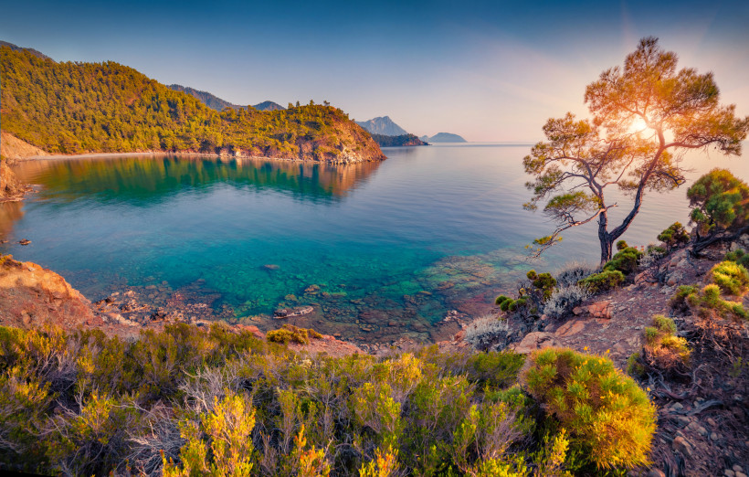 Herbstliche Küstenlandschaft in Kemer an der türkischen Riviera mit ruhigem Meer, grünen Hügeln und warmem Licht
