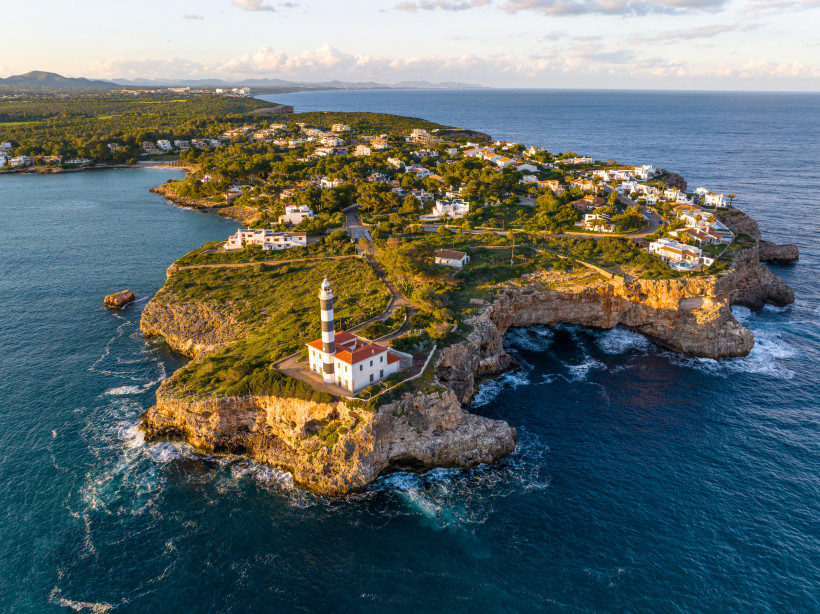 Leuchtturm Far de Portocolom auf felsiger Landzunge an der Küste von Mallorca, Luftaufnahme