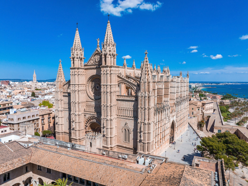 Außenansicht der Kathedrale La Seu in Palma de Mallorca mit gotischer Fassade und Rosettenfenster, Blick über die Altstadt bis zur Küste