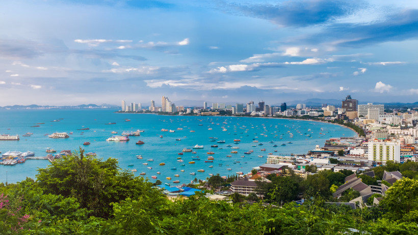 Panoramablick auf Pattaya mit Skyline, Strandpromenade und bunten Booten Weitwinkelblick auf die Skyline von Pattaya mit vielen Booten im türkisblauen Meer und Hochhäusern entlang der Küste