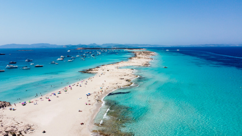 Ses Illetes: Sandstrand und flaches, türkisfarbenes Wasser mit vor Anker liegenden Booten Luftaufnahme des Strandes Ses Illetes mit langem Sandstreifen, Badegästen und Booten im türkisfarbenen Meer