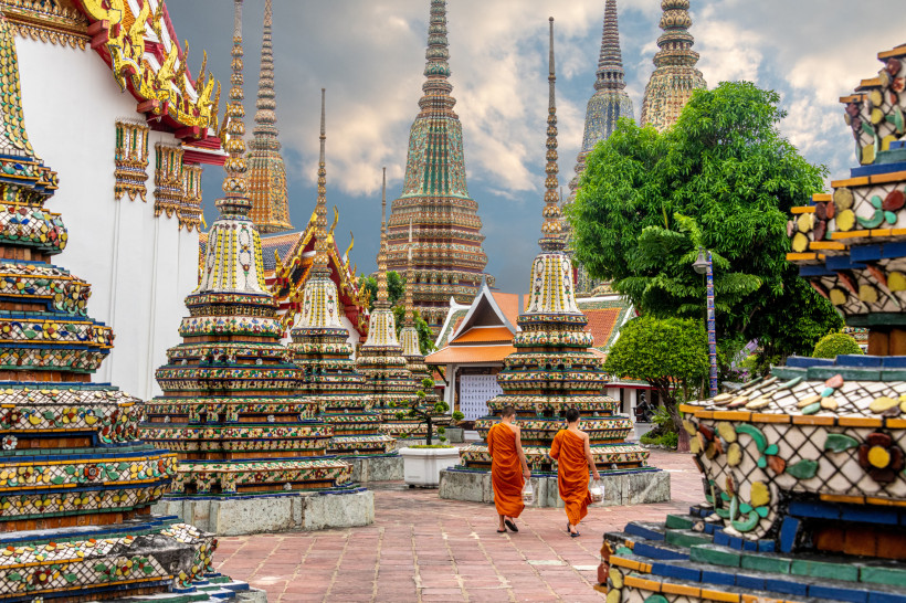 Wat Pho Bangkok – buddhistische Mönche und verzierte Chedis in der Tempelanlage Wat Pho Tempel in Bangkok mit farbenfrohen Chedis und buddhistischen Mönchen – traditionelle thailändische Architektur