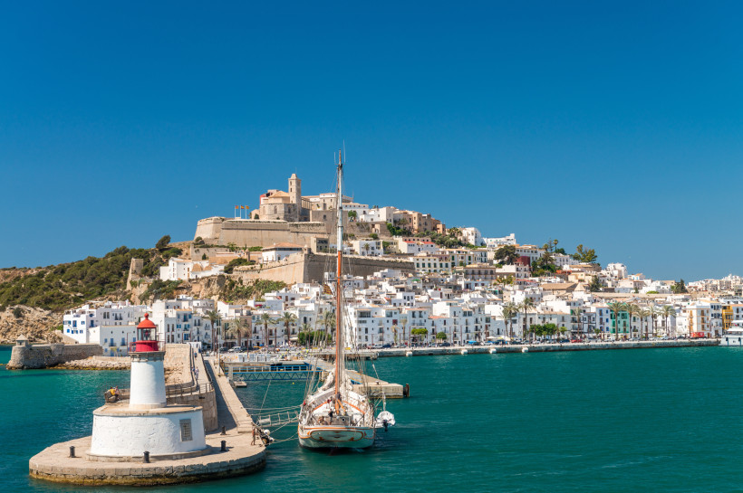 Hafenansicht von Ibiza-Stadt mit Festung Dalt Vila, weißen Häusern, Leuchtturm und Segelboot