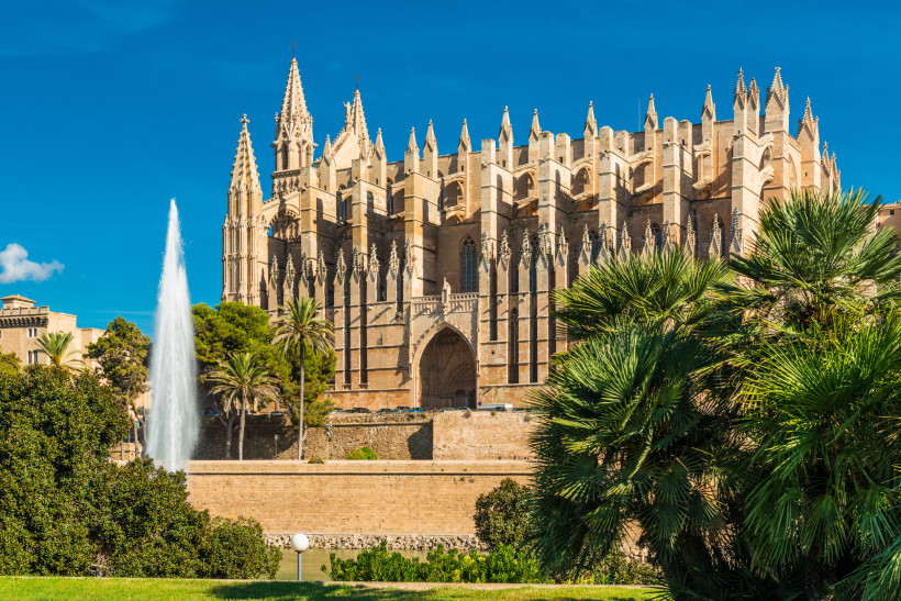 Kathedrale La Seu, Palma, Mallorca Kathedrale La Seu in Palma de Mallorca mit Palmen und Springbrunnen im Vordergrund bei sonnigem Wetter