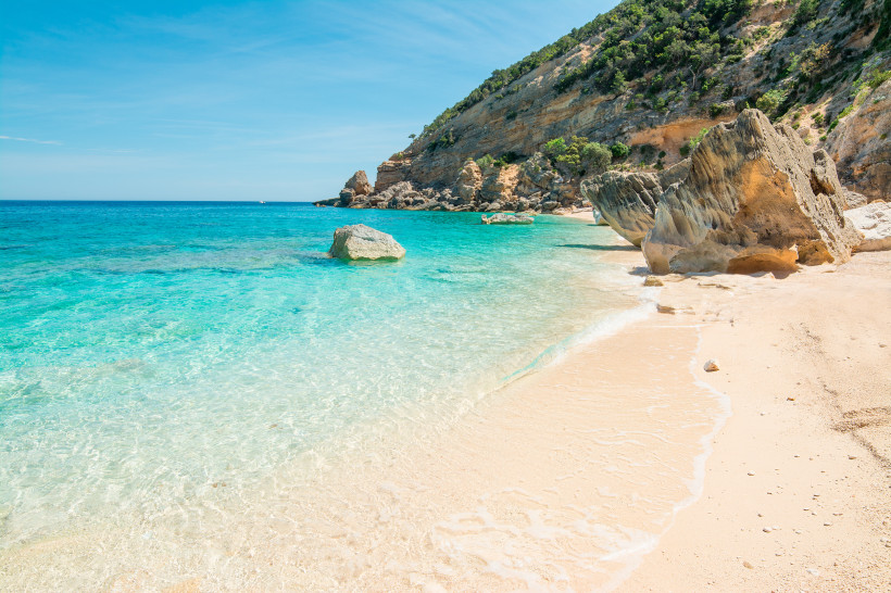 Traumstrand Cala Mariolu auf Sardinien mit weißem Sand, türkisblauem Wasser und Felsen an der Ostküste – einer der schönsten Orte der Insel
