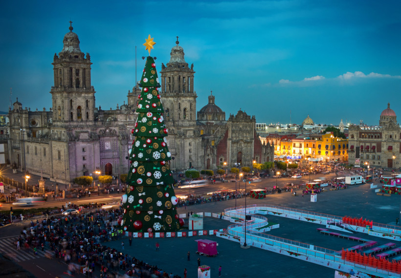 Weihnachten in Mexiko Großer Weihnachtsbaum mit Lichtern und Ornamenten auf dem Zócalo-Platz in Mexiko-Stadt, mit der Kathedrale und beleuchteten Gebäuden im Hintergrund