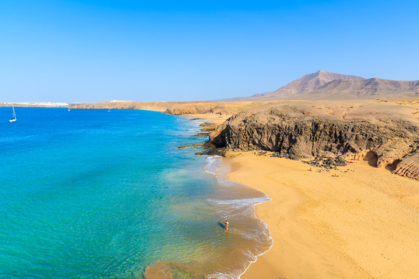 Lanzarote Strände – Traumküste für jeden Reisetyp Goldener Sandstrand und türkisblaues Meer auf Lanzarote – perfekte Kulisse für Paare, Familien, Erwachsene und Honeymoon-Reisen.