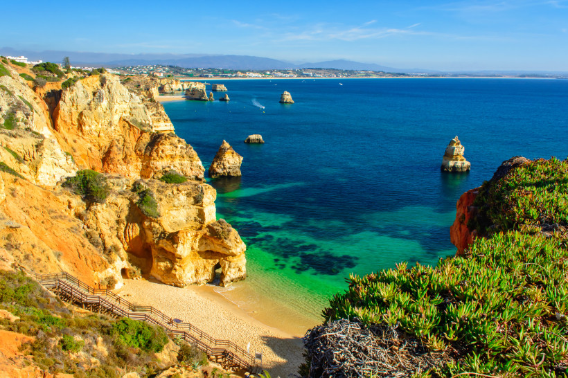 Küstenlandschaft an der Ponta da Piedade mit gelben Felsklippen, Sandstrand und Felsformationen im Meer