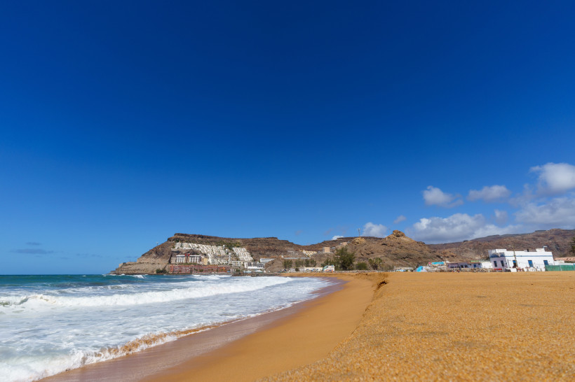 Sandstrand Playa de Tauro mit Brandung und Küstenhügeln, Gran Canaria, Spanien
