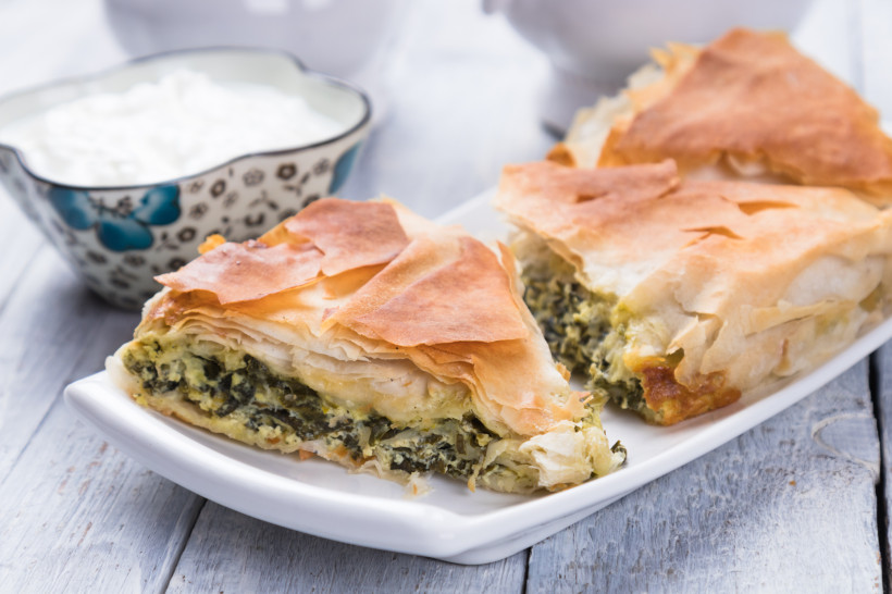 Zwei Stücke Spanakopita mit Spinat-Feta-Füllung im knusprigen Filoteig auf einem Teller