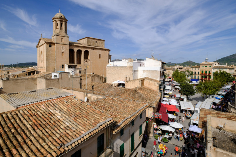 Plaça d’Espanya mit Blick über Dächer und Markttreiben, links eine Kirche mit Turm