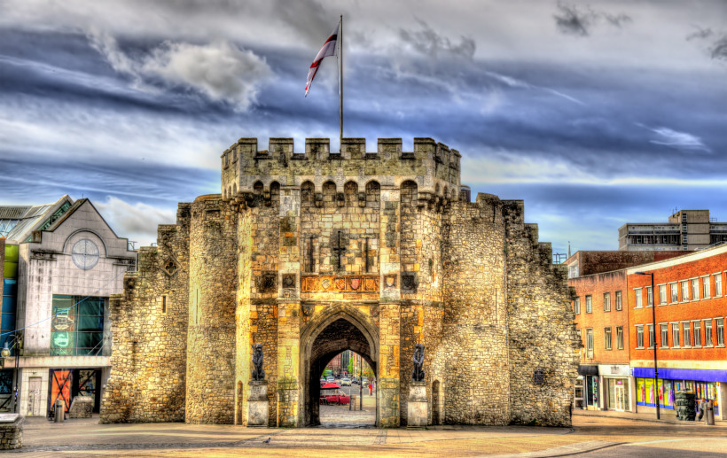 Bargate mit historischen Stadtmauern Bargate, mittelalterliches Stadttor mit historischen Stadtmauern und Fahne unter bewölktem Himmel