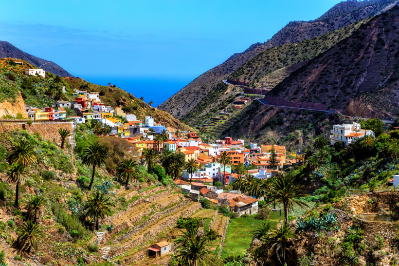 Farbenfrohes Dorf zwischen grünen Terrassenfeldern und Bergen auf der Kanarischen Insel La Gomera