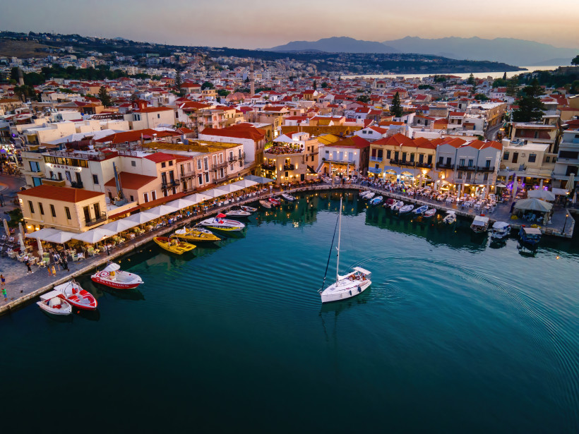 Venezianischer Hafen in Chania mit Booten und Uferpromenade bei Abenddämmerung
