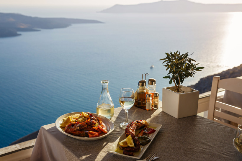Santorini, Griechenland Griechische Köstlichkeiten auf einem Tisch mit Blick aufs Meer