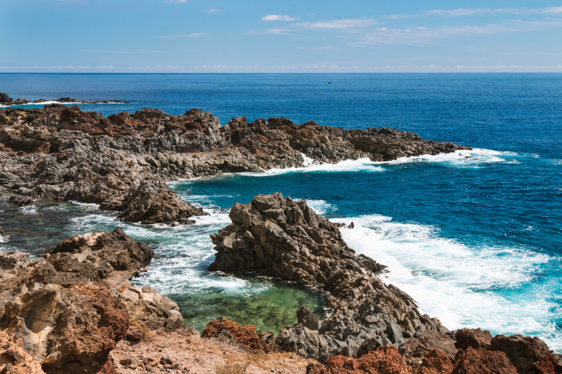 Felsige Küste an der Punta de Rasca mit Brandung und blauem Meer
