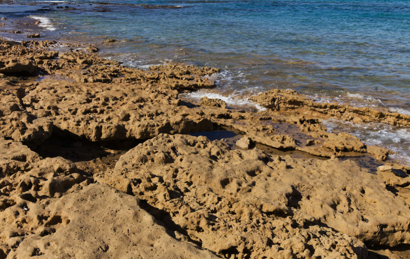 Felsige Küste an der Playa Chica in Las Palmas mit flachem Meerwasser