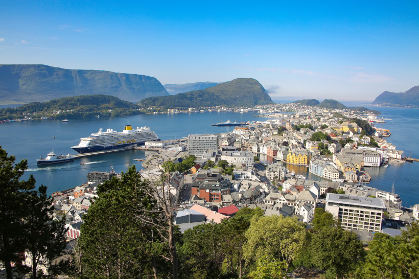 Panoramablick auf Ålesund mit Hafen, Stadtzentrum und Kreuzfahrtschiff, im Hintergrund Berge und Fjord