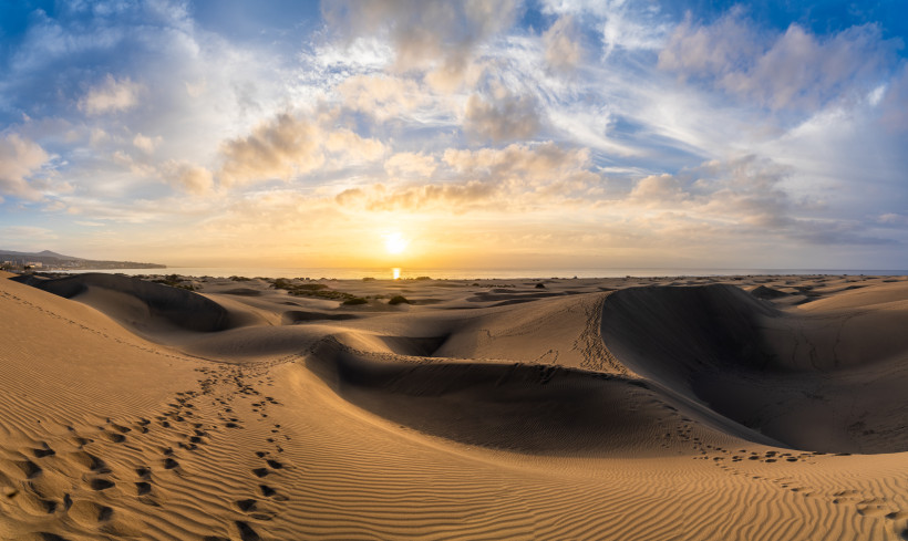 Sanddünen von Maspalomas auf Gran Canaria bei Sonnenuntergang, mit Wolkenhimmel und Blick zum Meer