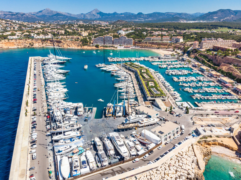 Luftaufnahme des Yachthafens Port Adriano mit zahlreichen Liegeplätzen, Molen und Booten an der Küste Mallorcas