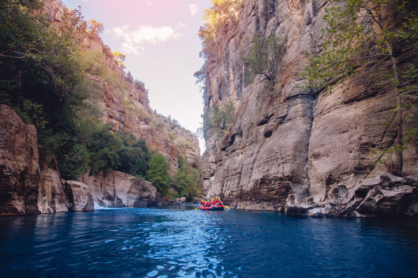 Gruppe beim Rafting im Köprülü-Canyon-Nationalpark nahe Belek, umgeben von hohen Felswänden und klarem, blauem Flusswasser – beliebtes Outdoor-Erlebnis an der Türkischen Riviera