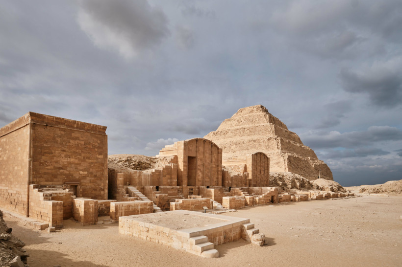 Ägypten - Makadi Bay Blick auf die Stufenpyramide von Sakkara in Ägypten, eine der ältesten Pyramiden der Welt. Im Vordergrund sind gut erhaltene Überreste antiker Tempel- und Grabarchitektur zu sehen, bestehend aus großen Sandsteinblöcken. Die Pyramide erhebt sich im Hinterg