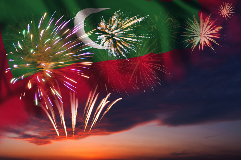 Malediven Ein spektakuläres Feuerwerk erleuchtet den Himmel vor der Nationalflagge der Malediven. Die bunten Lichter spiegeln sich in der Abenddämmerung und schaffen eine feierliche Atmosphäre.