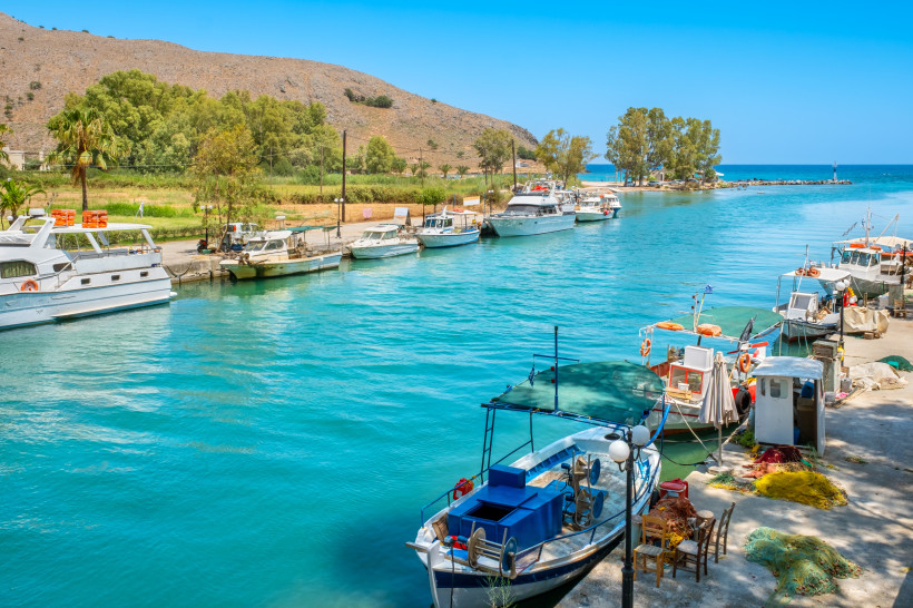 Hafenkanal in Georgioupolis mit Booten am Ufer und türkisfarbenem Wasser