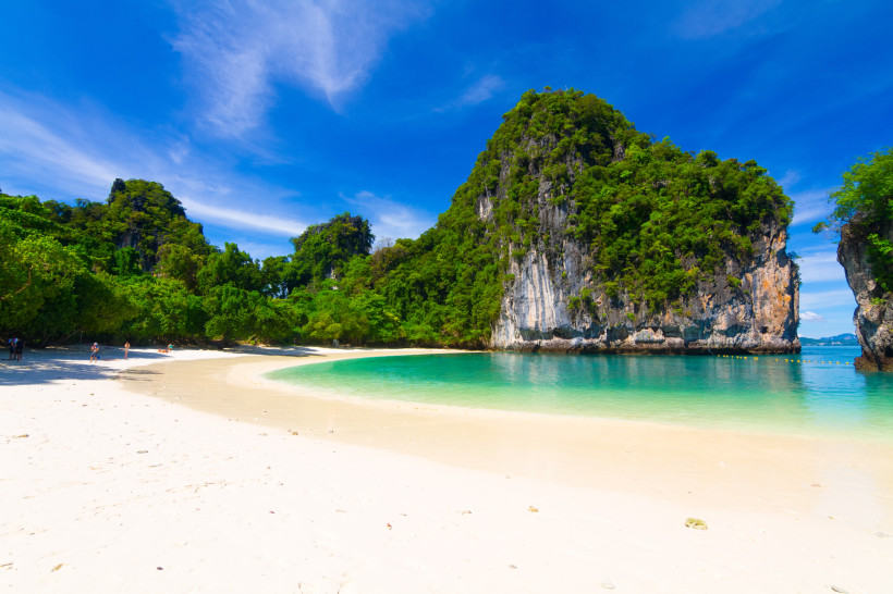 Hong Island bei Krabi, Thailand: idyllische Sandbucht mit türkisfarbenem Meer, grüner Vegetation und Kalksteinfelsen.