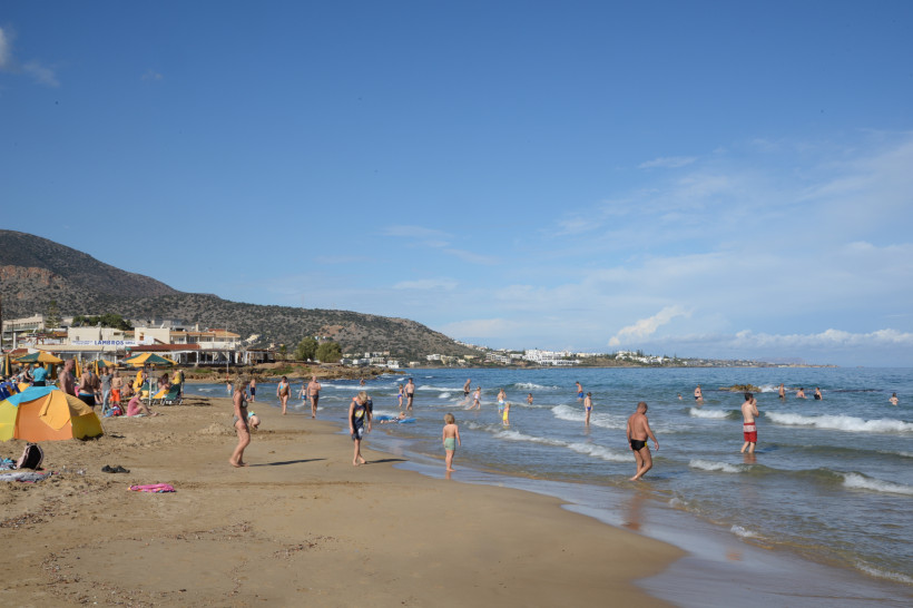 Familienurlaub in Stalida am Strand Strand in Stalida mit Familien am Ufer und im flachen Wasser, im Hintergrund Küste und Berge