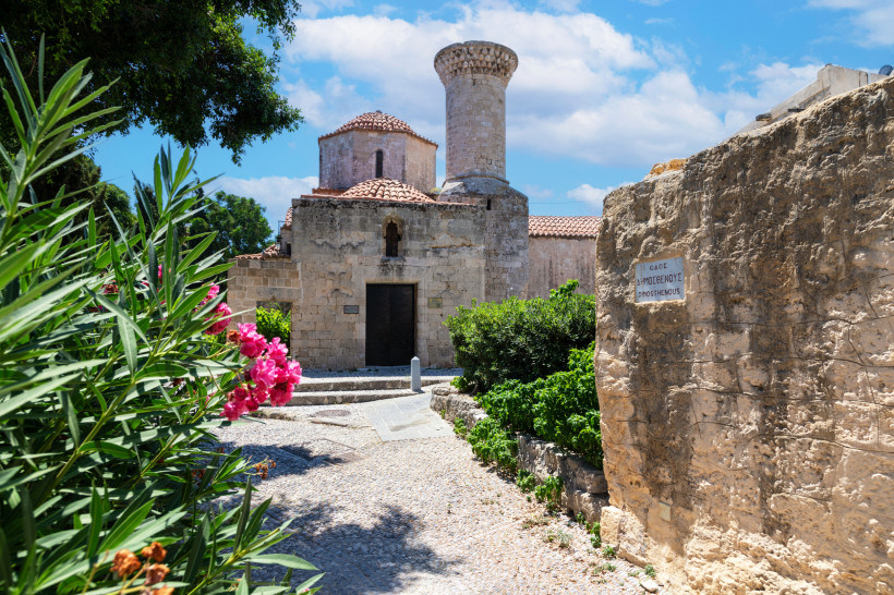 Historische byzantinische Kirche in Rhodos-Stadt mit Natursteinmauern, Blumen und traditioneller Architektur