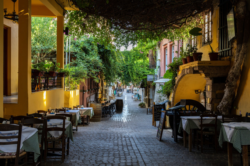 Gepflasterte Gasse im Altstadt-Viertel Splantzia mit Tischen, Stühlen und überhängendem Blätterdach