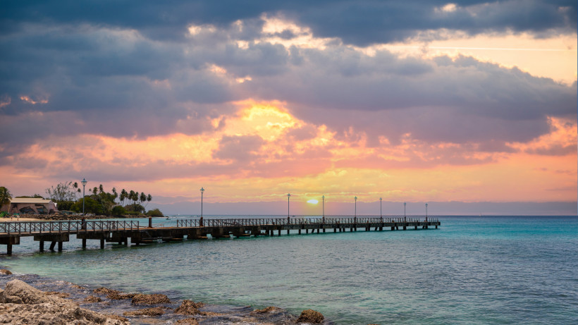 Sonnenuntergang am Pier – romantische Abendstimmung auf Barbados Sonnenuntergang über dem Meer auf Barbados mit Pier und orangefarbenem Himmel.