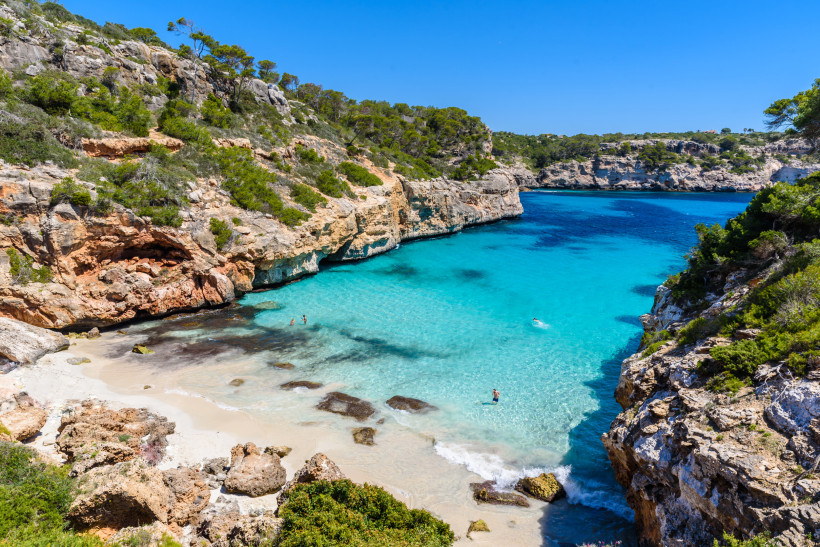 Bucht Cala des Moro auf Mallorca mit türkisfarbenem Wasser, Sandstrand und Felsklippen