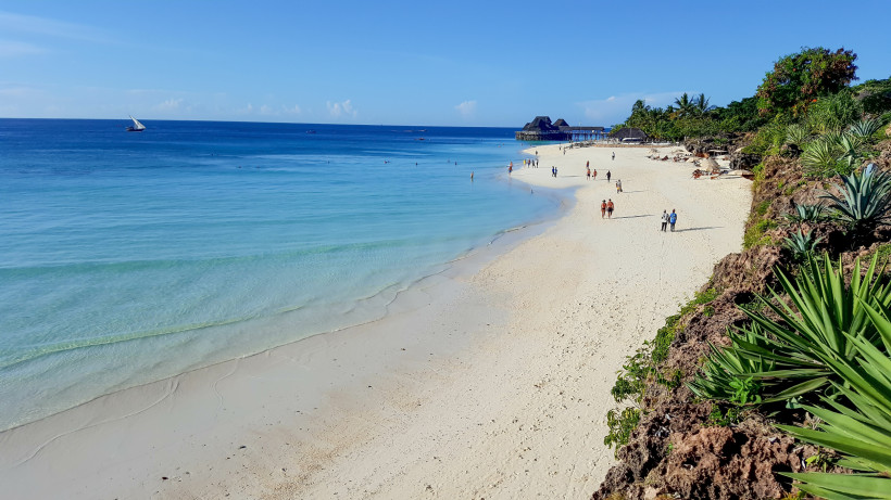 Sansibar - Kendwa Strand auf Sansibar mit weißem Sand, türkisblauem Meer und traditionellem Dhow-Segelboot im Hintergrund