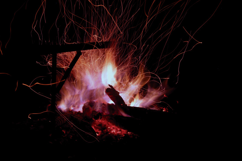Ein brennendes Lagerfeuer mit intensiven Flammen und Funken, die in die Nacht steigen