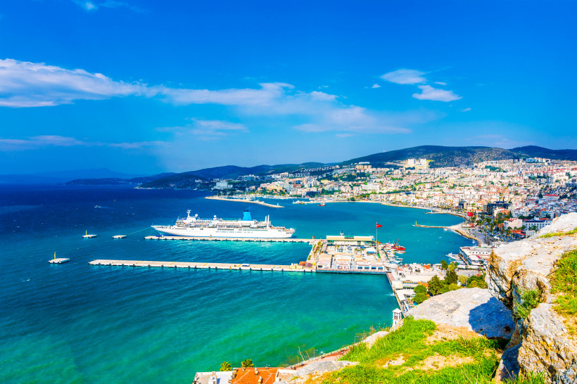 Blick auf den Hafen von Kusadasi mit Kreuzfahrtschiff, Altstadt und türkisblauem Meer – beliebtes Reiseziel für Urlaub in der Türkei 2026/2027