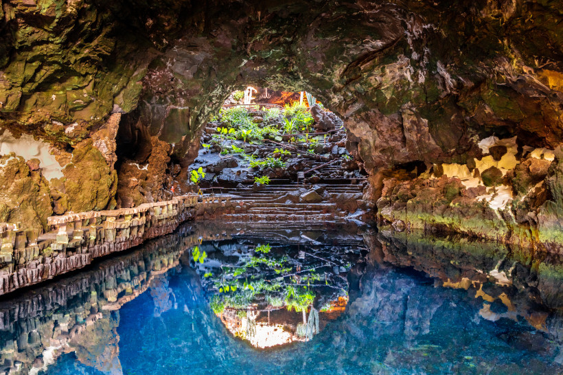 Jameos del Agua – Vulkanhöhle und Kulturstätte auf Lanzarote Blick aus einer vulkanischen Lavahöhle mit klarem Wasserbecken und üppiger Pflanzenkulisse im Hintergrund auf Lanzarote