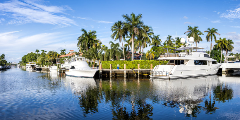Yachten an einem Kanal mit Palmen und Wohnhäusern in Fort Lauderdale