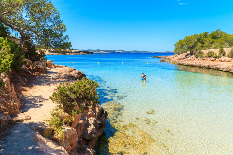 Cala Gracio mit flacher Badebucht, klarem Wasser und felsiger Küste