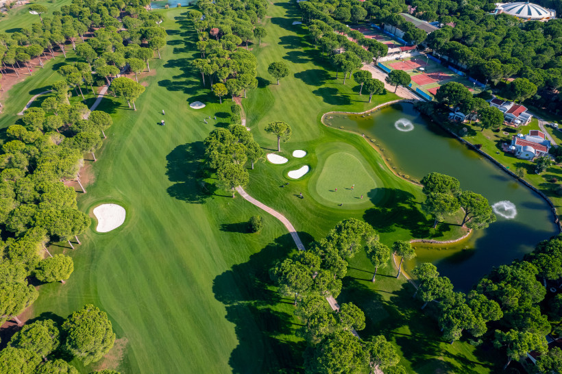 Golf in Belek – Luftaufnahme eines Premium-Golfplatzes mit Seen und Fairways Drohnenaufnahme eines weitläufigen Golfplatzes in Belek mit Greens, Bunkern und Wasserhindernissen