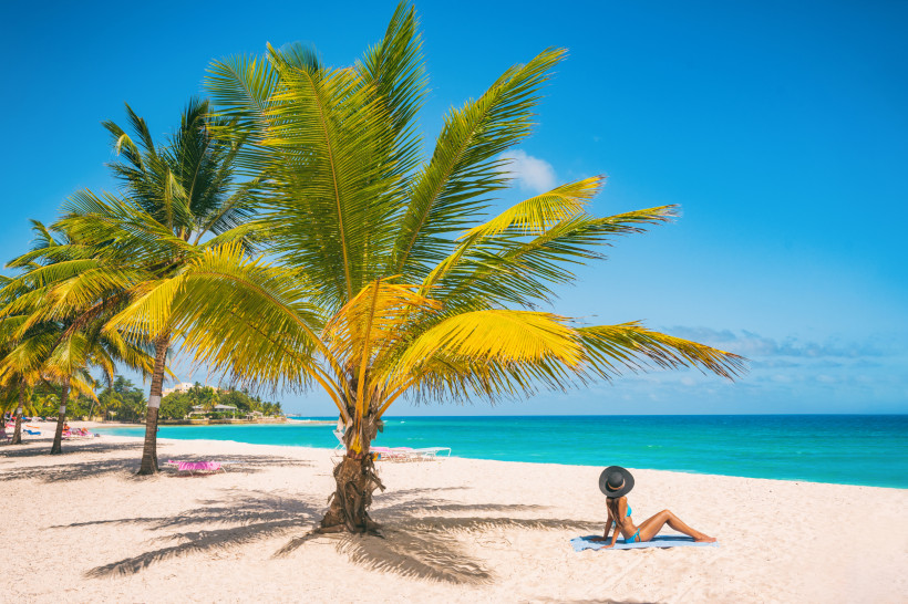 Sandstrand auf Barbados mit Palmen und Blick auf das türkisfarbene Meer