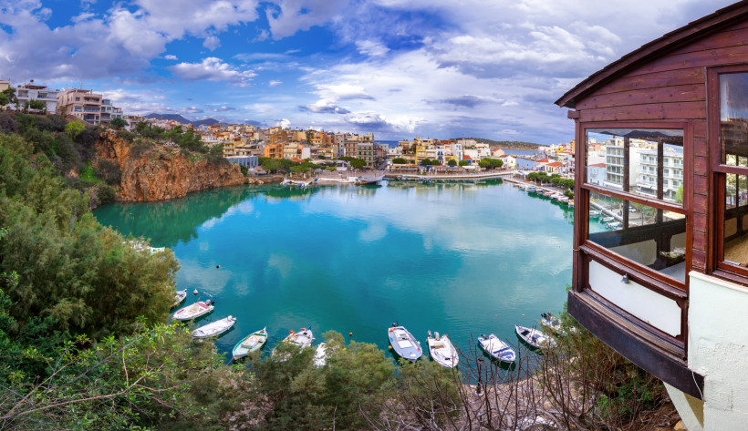 Voulismeni-See in Agios Nikolaos mit Booten und Uferbebauung Blick auf den Voulismeni-See in Agios Nikolaos mit türkisfarbenem Wasser, Booten und Stadtbebauung am Ufer
