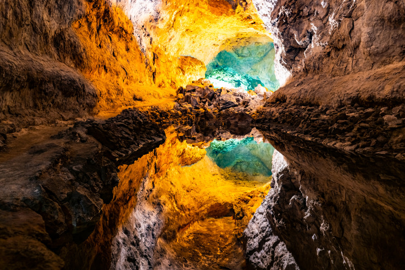Cueva de los Verdes – spektakulär beleuchteter Lavatunnel mit unterirdischem See Spektakulär beleuchteter Abschnitt der Cueva de los Verdes auf Lanzarote mit unterirdischem Wasserbecken und farbigen Lavawänden.