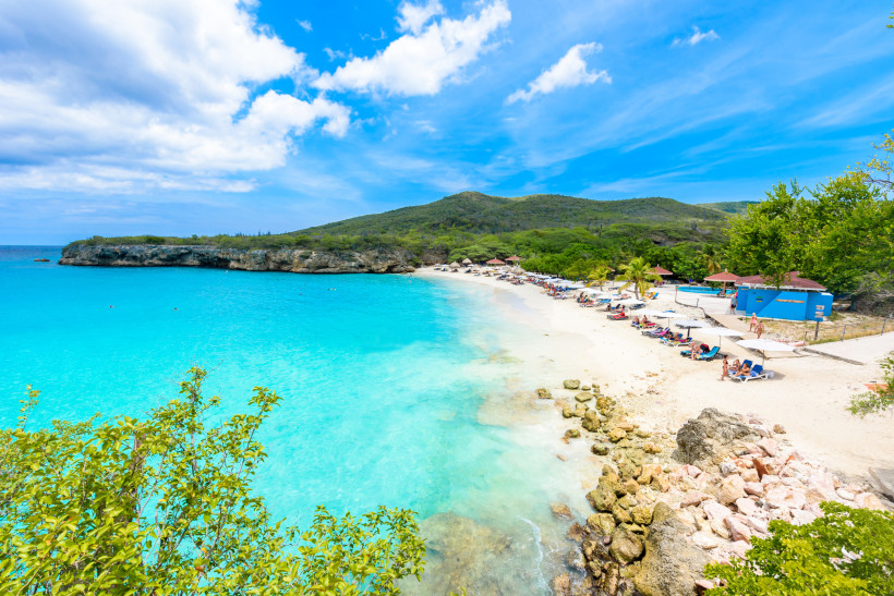 Playa Grote Knip – Traumstrand auf Curaçao mit türkisblauem Meer Playa Grote Knip auf Curaçao – traumhafter Sandstrand mit türkisblauem Wasser, Sonnenliegen und grüner Küstenlandschaft