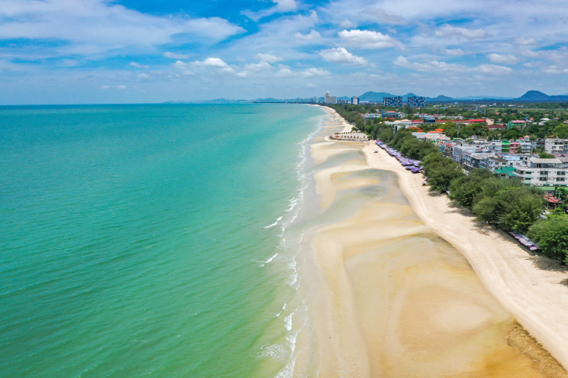 Luftaufnahme vom langen Sandstrand in Cha-am, Thailand mit Blick auf das türkisfarbene Meer und die Küstenlinie von Hua Hin