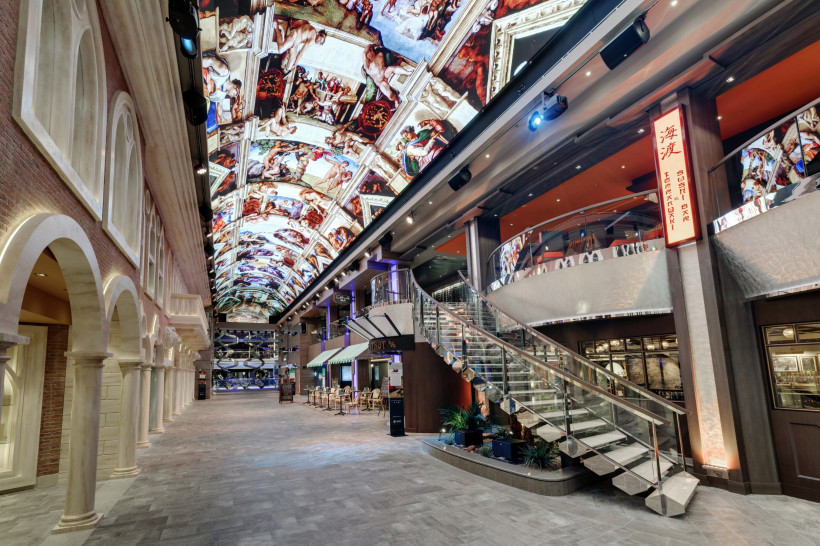 MSC Grandiosa: Innenansicht der Galleria Grandiosa mit Treppe und LED-Deckeninstallation Galleria Grandiosa auf der MSC Grandiosa mit LED-Kuppeldecke, Treppenaufgang und Geschäften